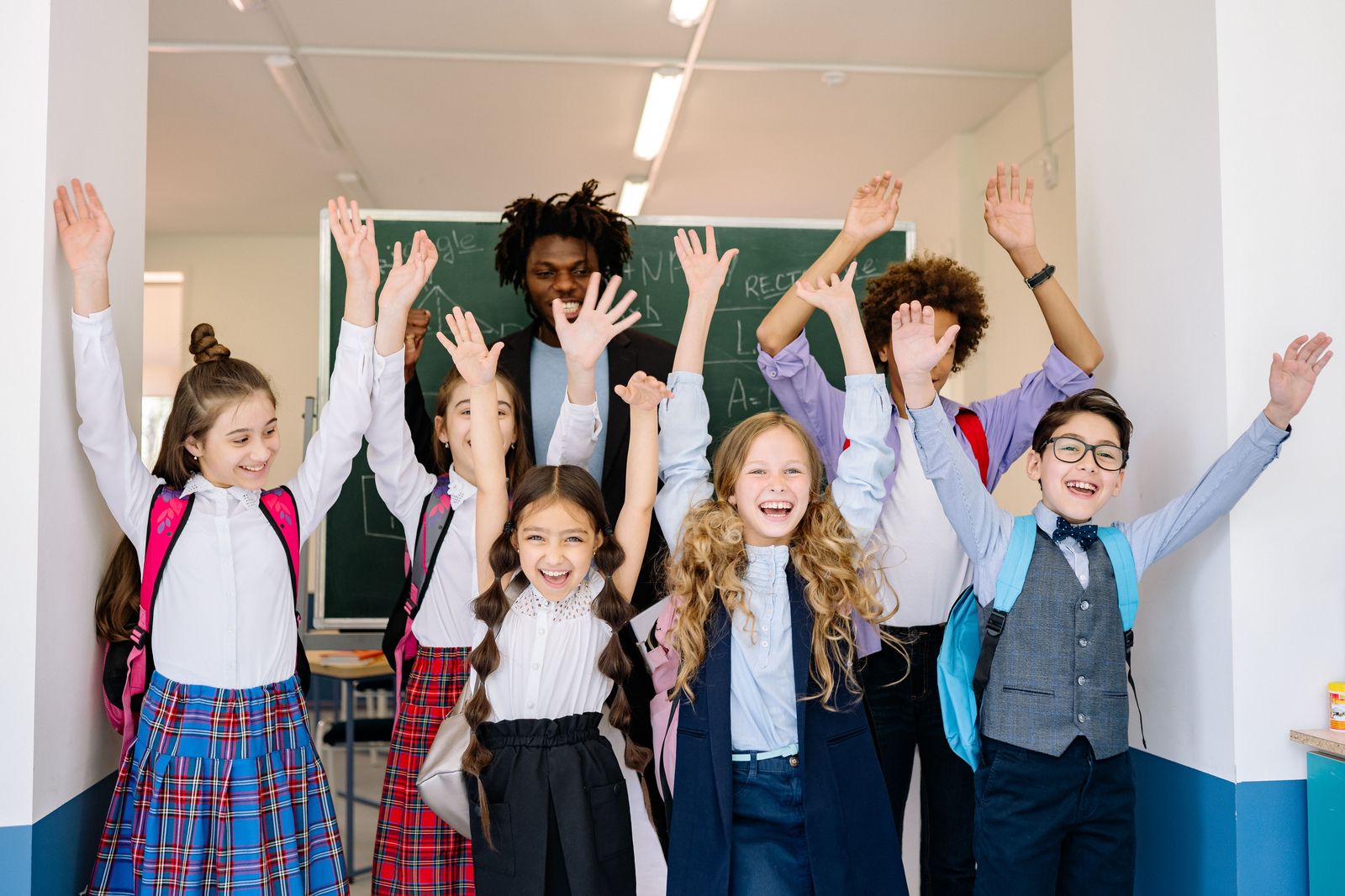 A group of joyful students with their arms raised